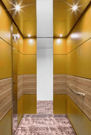 Cabina de elevador comercial con acabados dorados
